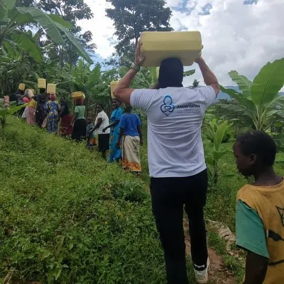 The Anonymous Project in Bududa, helping to carry water back to the village.